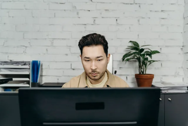 An office worker concentrating on tasks at his modern desk in a contemporary setting. Estimating savings from measured handling time